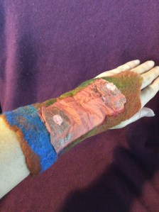 A slip of sari silk cozies with silk and merino felt, closed with a handmade wooden button 